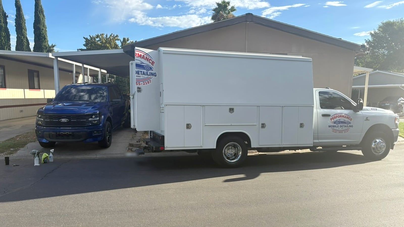 White utility-body service truck with the Performance Mobile Detailing logo parked at a curb